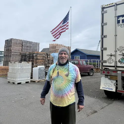 Bill Lancaster on the dock, the largest flag in Homer flying behind him